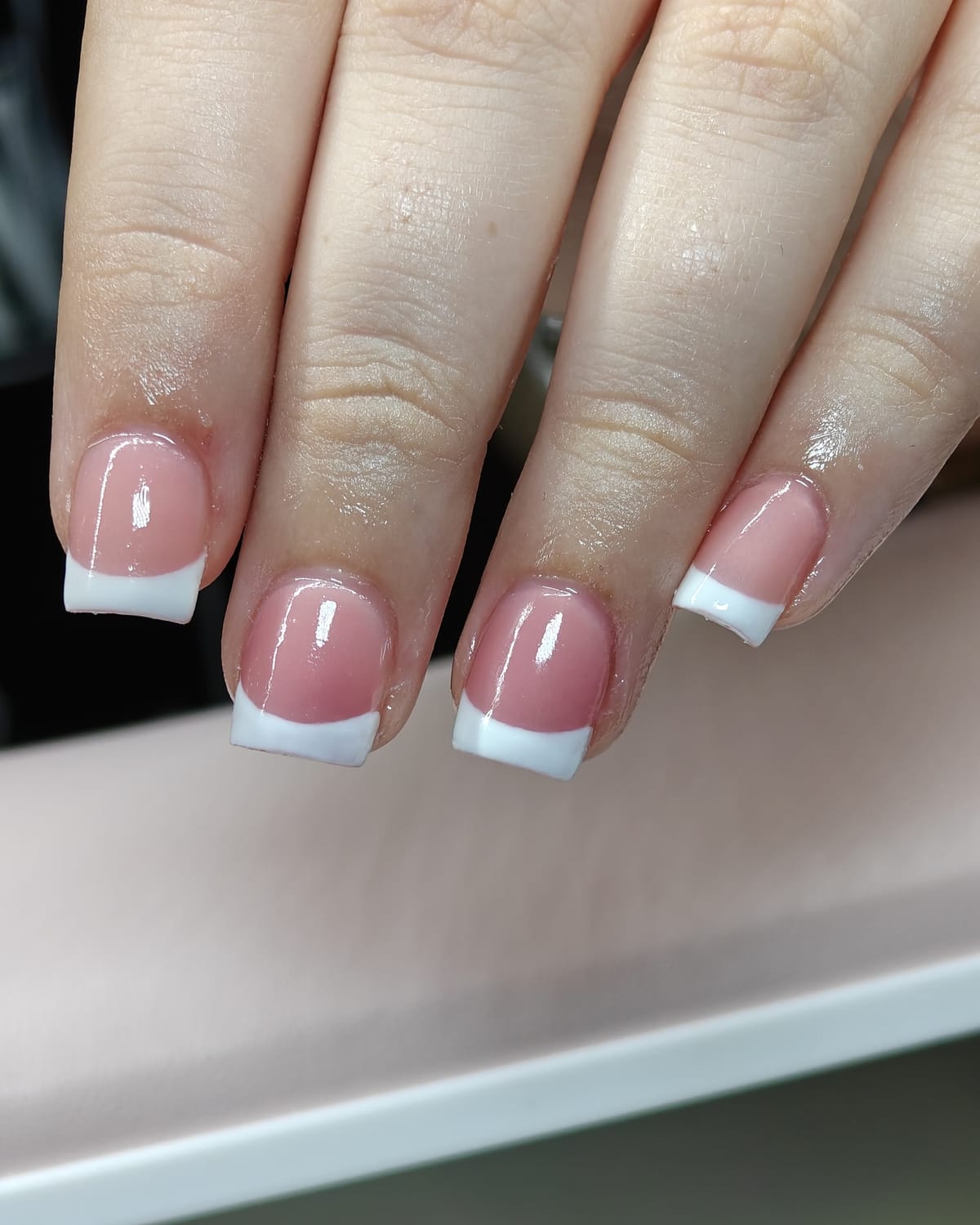 Nail work from Only Nails Beauty — a classic pink and white French manicure on square nails.