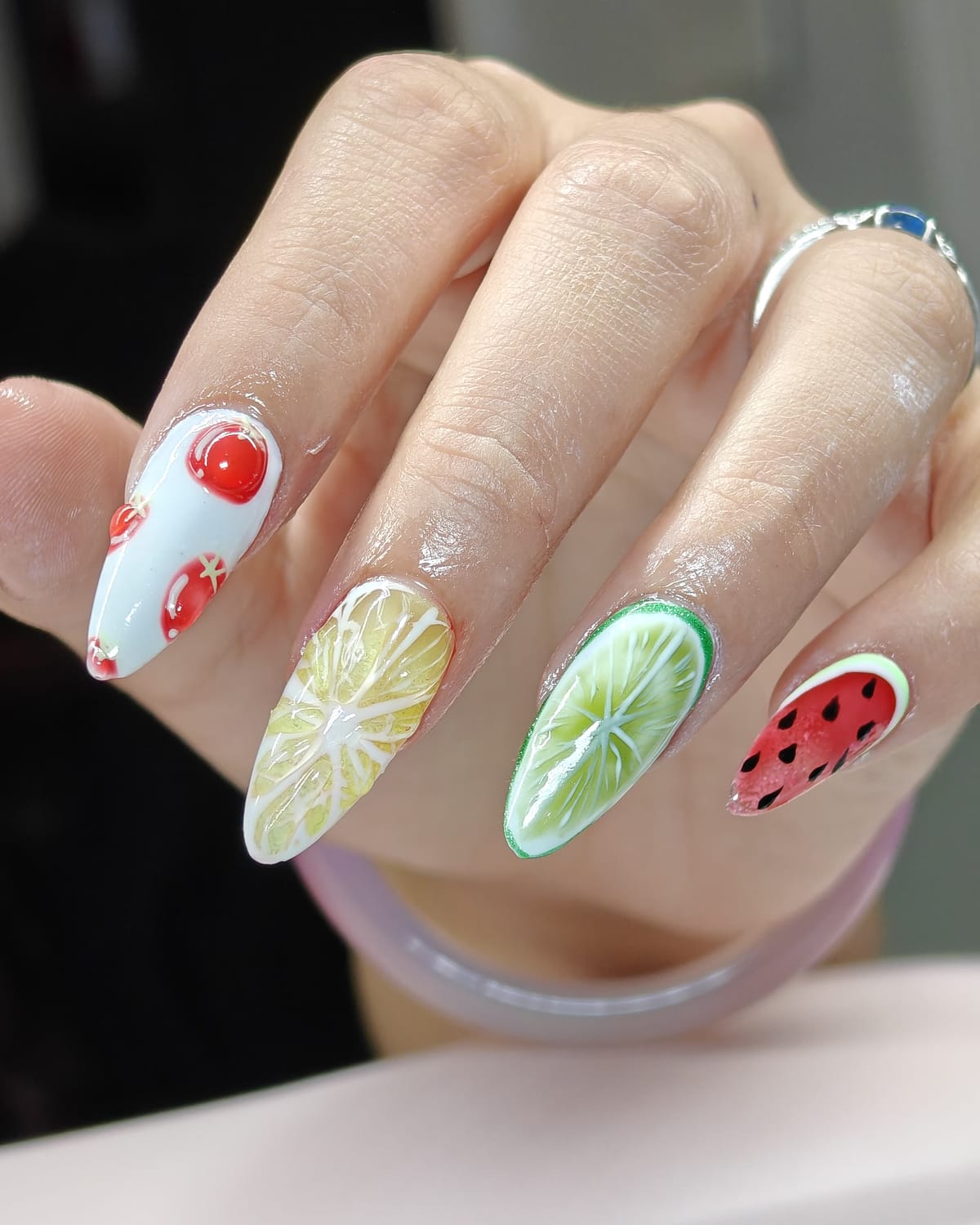 Almond nails with glossy 3D fruit nail art: lemon and lime slices, raised cherries and a watermelon tip.